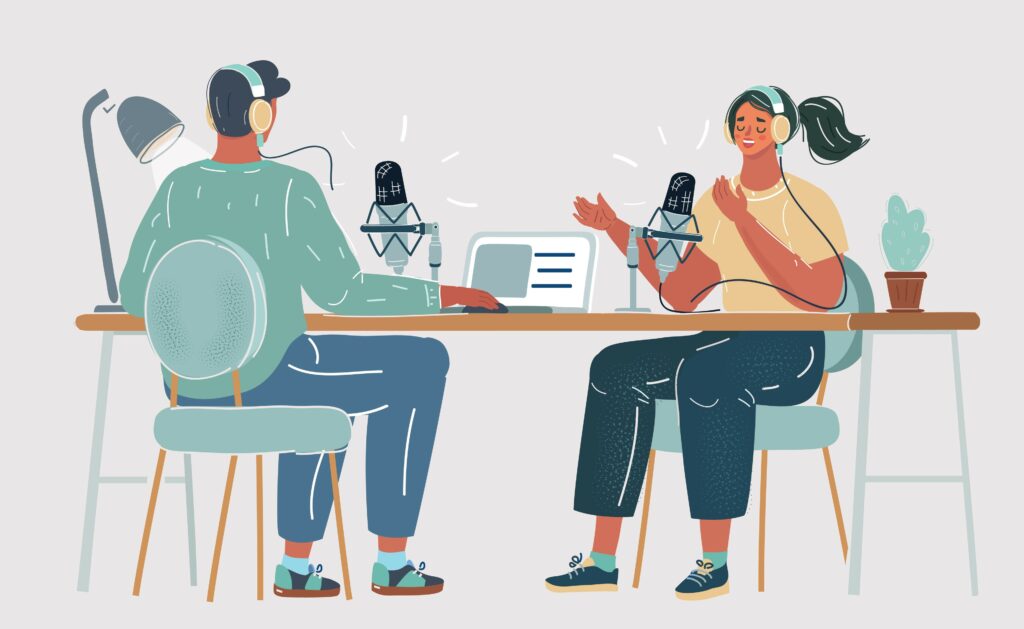 Two people sitting at a table together recording a podcast.
